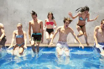 un grupo de adolescentes saltando en la piscina