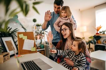Familia feliz usando una computadora portátil para hablar con amigos y familiares