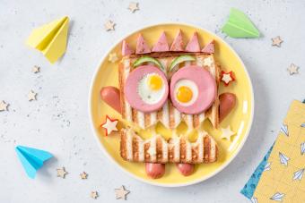 Sándwich de monstruo con salchicha, huevos y queso en un plato