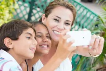 Madrastra tomándose una selfie con sus hijos