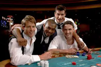 Cuatro hombres sentados en un casino jugando a la ruleta