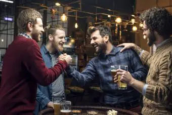 Grupo de amigos bebiendo cerveza en el pub juntos