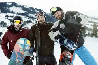 Amigos con tablas de snowboard en vacaciones de invierno