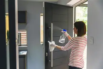 Mujer limpiando la puerta principal