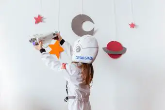 chica con traje espacial jugando con cohetes 