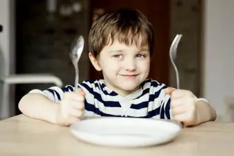 Niño feliz esperando la cena