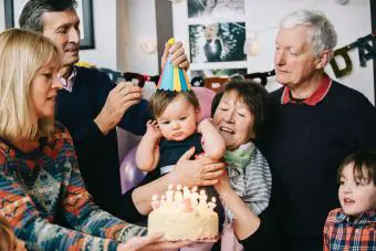 Familia celebrando el cumpleaños de los niños pequeños con pastel