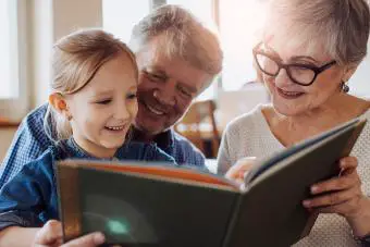 Abuelos leyendo un libro a su nieta
