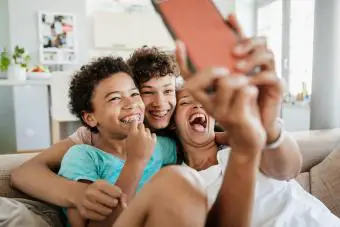 Mamá jugando con sus hijos mirando un teléfono inteligente