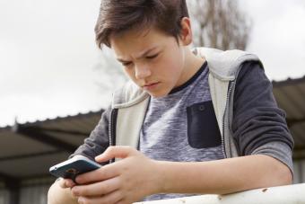 Adolescente confundido mirando su teléfono inteligente 