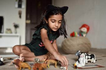 niña alineando juguetes de animales