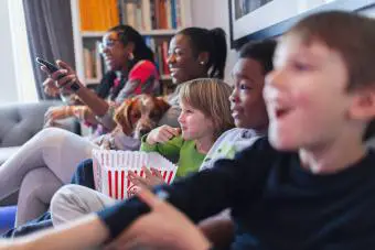 Familia multiétnica viendo películas y comiendo palomitas de maíz