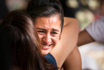 mujer abrazando a su hija y llorando 