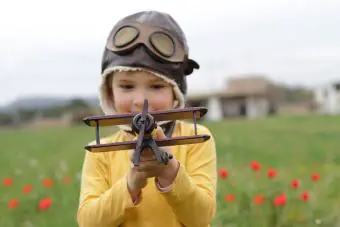 Niño jugando con avión de juguete 
