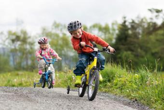 Niño pequeño y su hermana menor en bicicleta al aire libre