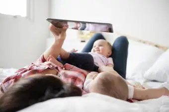 mamá con niños leyendo una revista en línea