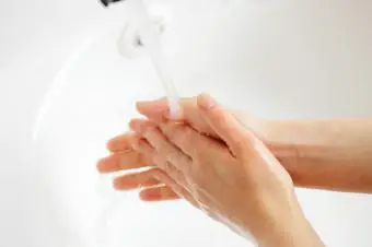Persona mojándose las manos con agua