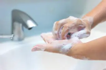 Persona frotándose las uñas con jabón