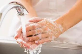 Persona enjuagando jabón de manos