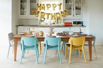 Sillas dispuestas alrededor de una mesa de comedor en la cocina en una fiesta de cumpleaños en casa