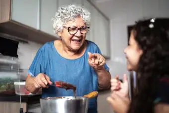 Abuela haciendo chocolate con nieta en casa