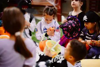 Niños jugando Scavenger hunt juego de Halloween en la fiesta del patio trasero