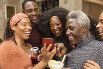 Familia multigeneracional feliz usando un teléfono inteligente
