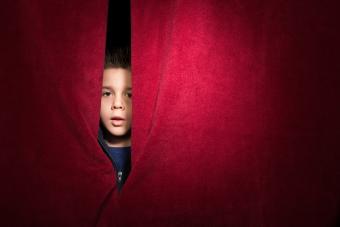 Niño que aparece detrás de la cortina