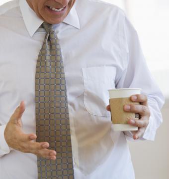 hombre de negocios derramando café en la camisa