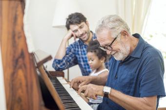 Abuelo tocando el piano con su nieta y su hijo 
