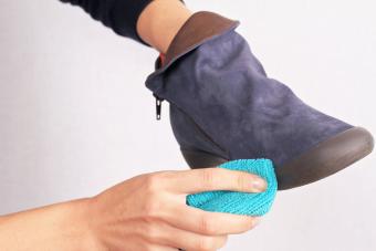Mujer limpiando botas de gamuza para el cuidado de invierno