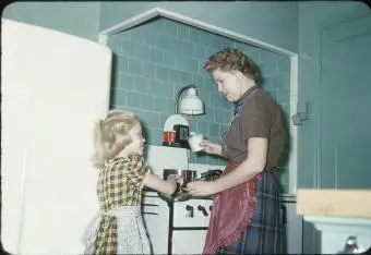 1950 madre enseñando a su hija a cocinar