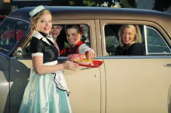 auto de salto de la década de 1950 en un restaurante con clientes adolescentes