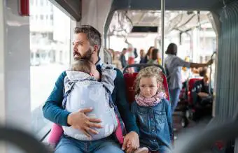 Padre con hijos en un bus en la ciudad