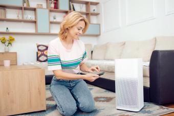 Mujer ajustando un filtro de aire doméstico