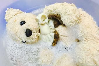 lavar a mano el animal de peluche del oso de peluche en el fregadero