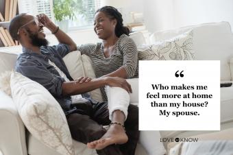 pareja romántica en el sofá de casa riéndose juntos