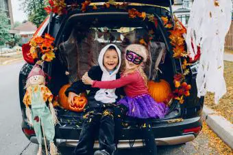 hermano y hermana en la parte trasera de una minivan para Halloween Trunk or Treat