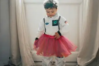 niño jugando a hacer creer en un traje de astronauta con un tutú