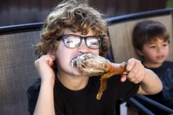 Un niño comiendo una pierna de pavo en Acción de Gracias