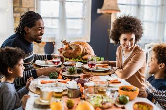 Familia feliz comunicándose mientras almuerza el Día de Acción de Gracias