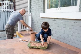 Padre e hijo trabajando juntos para pintar el porche