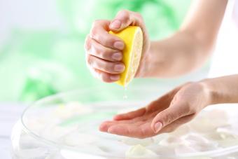 Mujer exprimiendo jugo de limón en su mano