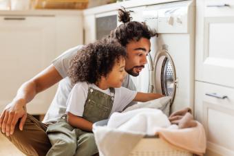 niño lavando la ropa con papá