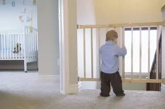 bebé mirando a través de la puerta para bebés al lado de su habitación