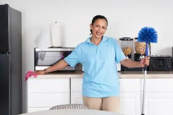 Mujer limpiando una habitación con un trapo de telaraña
