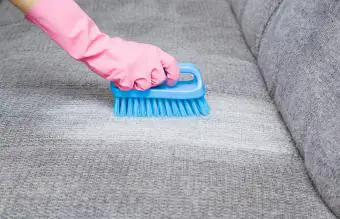 quitar la mancha del sofá gris con un cepillo 