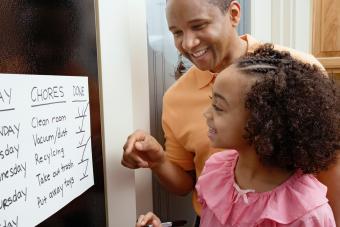Padre africano e hija mirando el gráfico de tareas 
