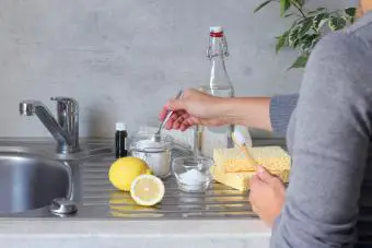 Mujeres preparando un limpiador natural no químico en casa con bicarbonato de sodio, vinagre y limón
