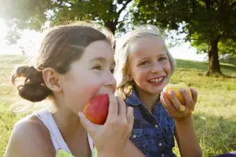 dos niñas comiendo manzanas